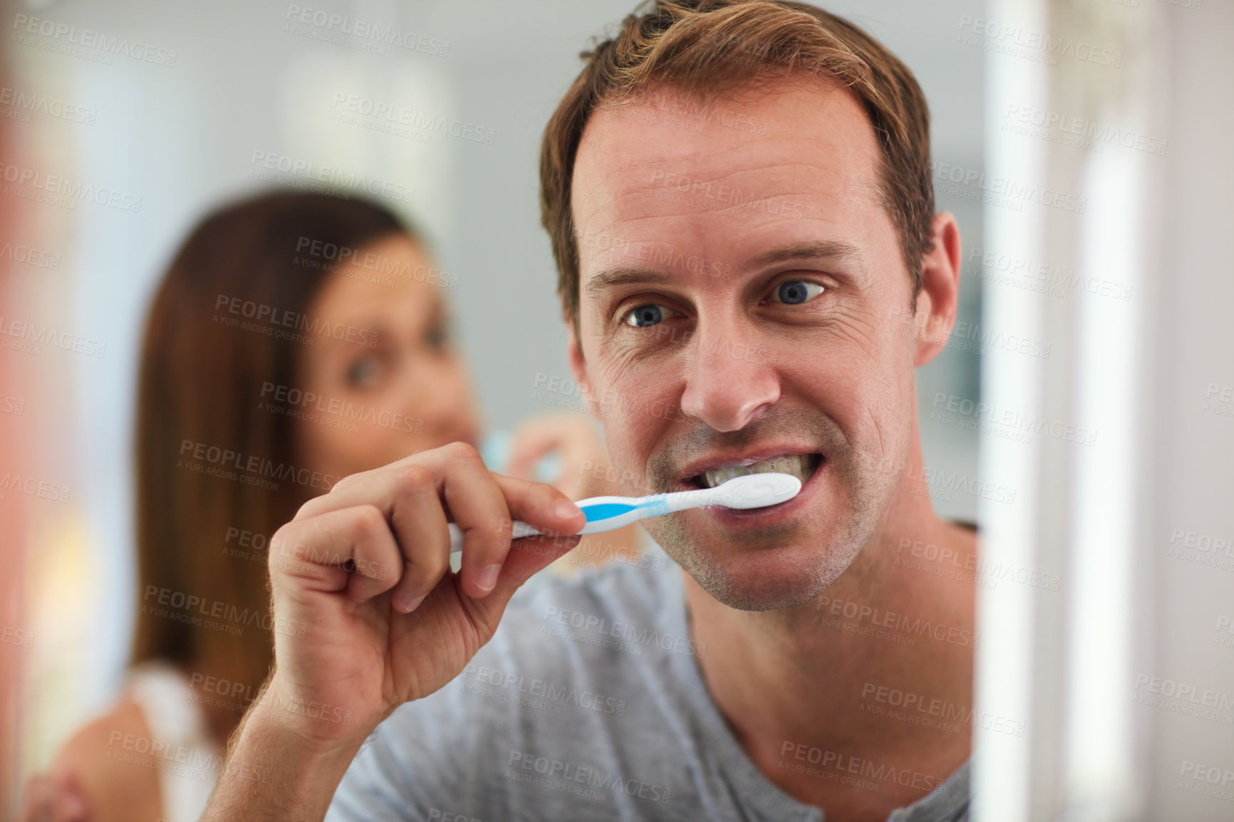 Buy stock photo Shot of a mature couple brushing their teeth together in the bathroom