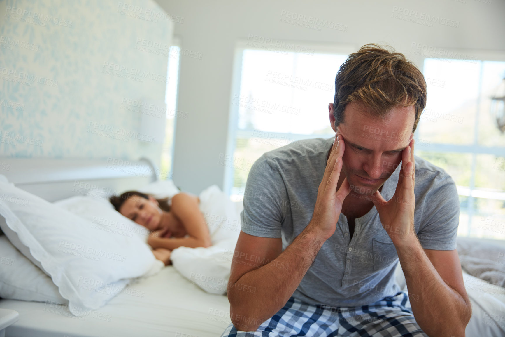 Buy stock photo Married, thinking and man in bedroom at house with stress, anxiety and problem of secret from cheating on sleeping woman. Frustrated, male person and fear of infertility dream with insomnia crisis