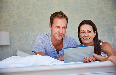 Buy stock photo Portrait of a mature couple using a digital tablet while relaxing in bed together