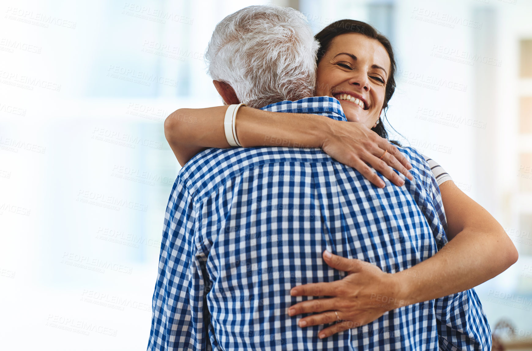 Buy stock photo Cropped shot of a woman hugging her elderly father at home