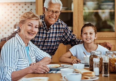 Buy stock photo Portrait of a little girl having breakfast with her grandparents at home