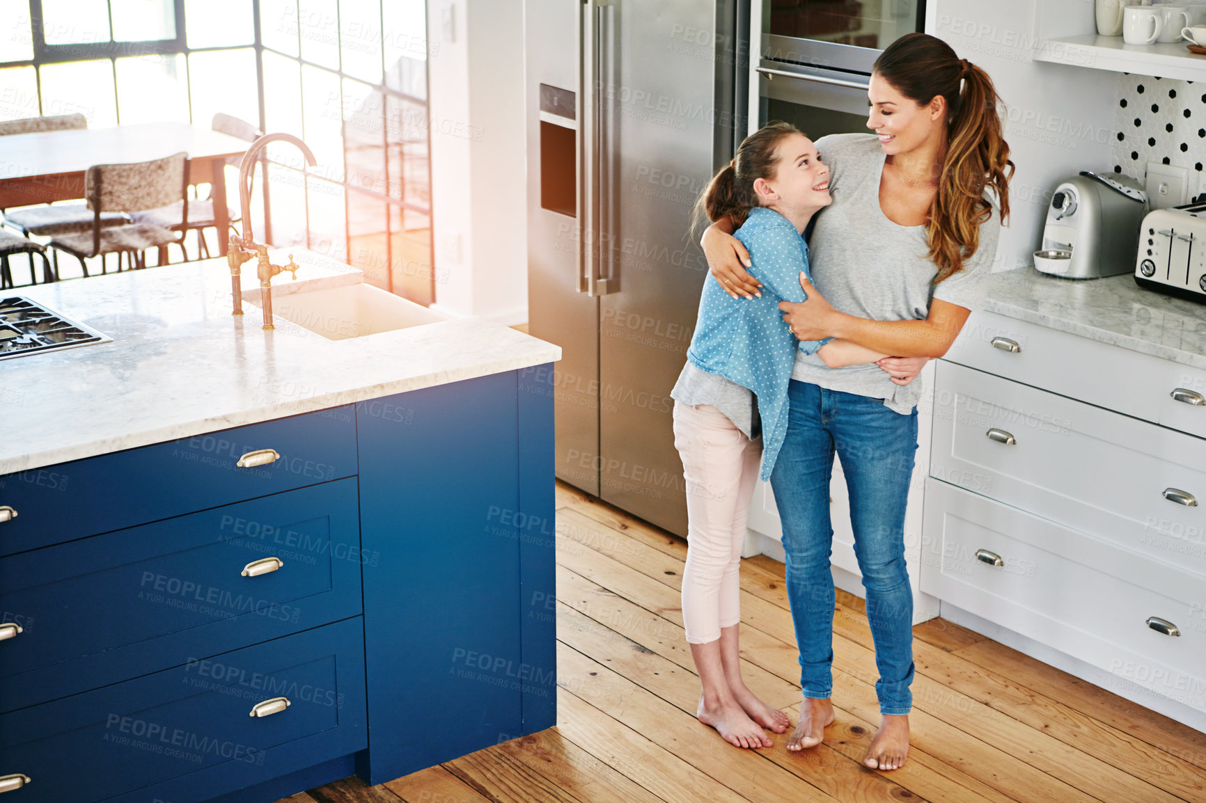 Buy stock photo Shot of a happy mother and daughter in a loving embrace at home