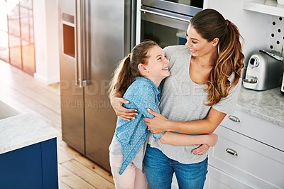 Buy stock photo Shot of a happy mother and daughter in a loving embrace at home