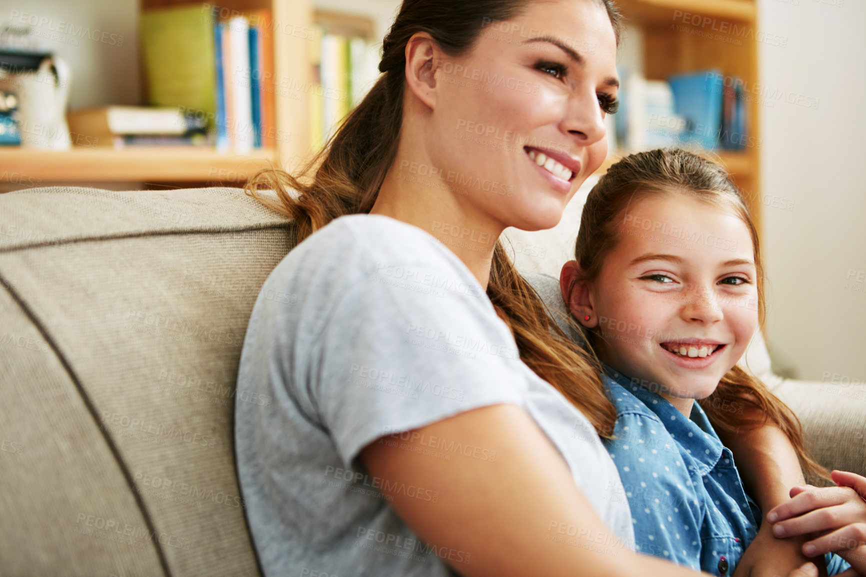 Buy stock photo Portrait of a happy mother and daughter relaxing together on the sofa at home