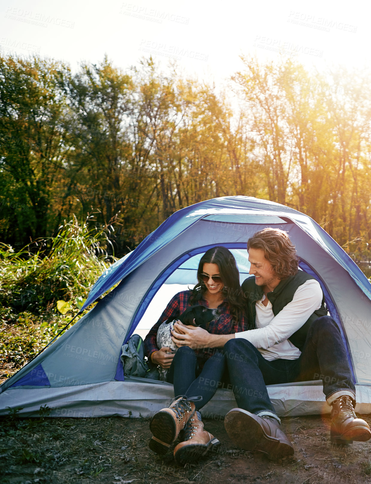 Buy stock photo Couple, camping and dog by tent in nature for adventure, freedom and vacation or peace. People, puppy and relax in woods or forest by lake for summer holiday, memory and outdoor experience at morning