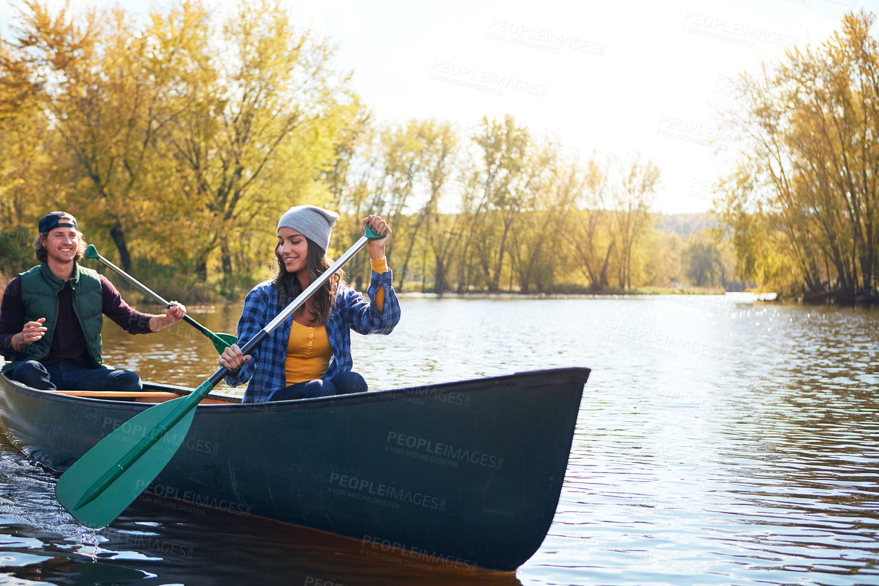 Buy stock photo Shot of a young couple going for a canoe ride on the lake