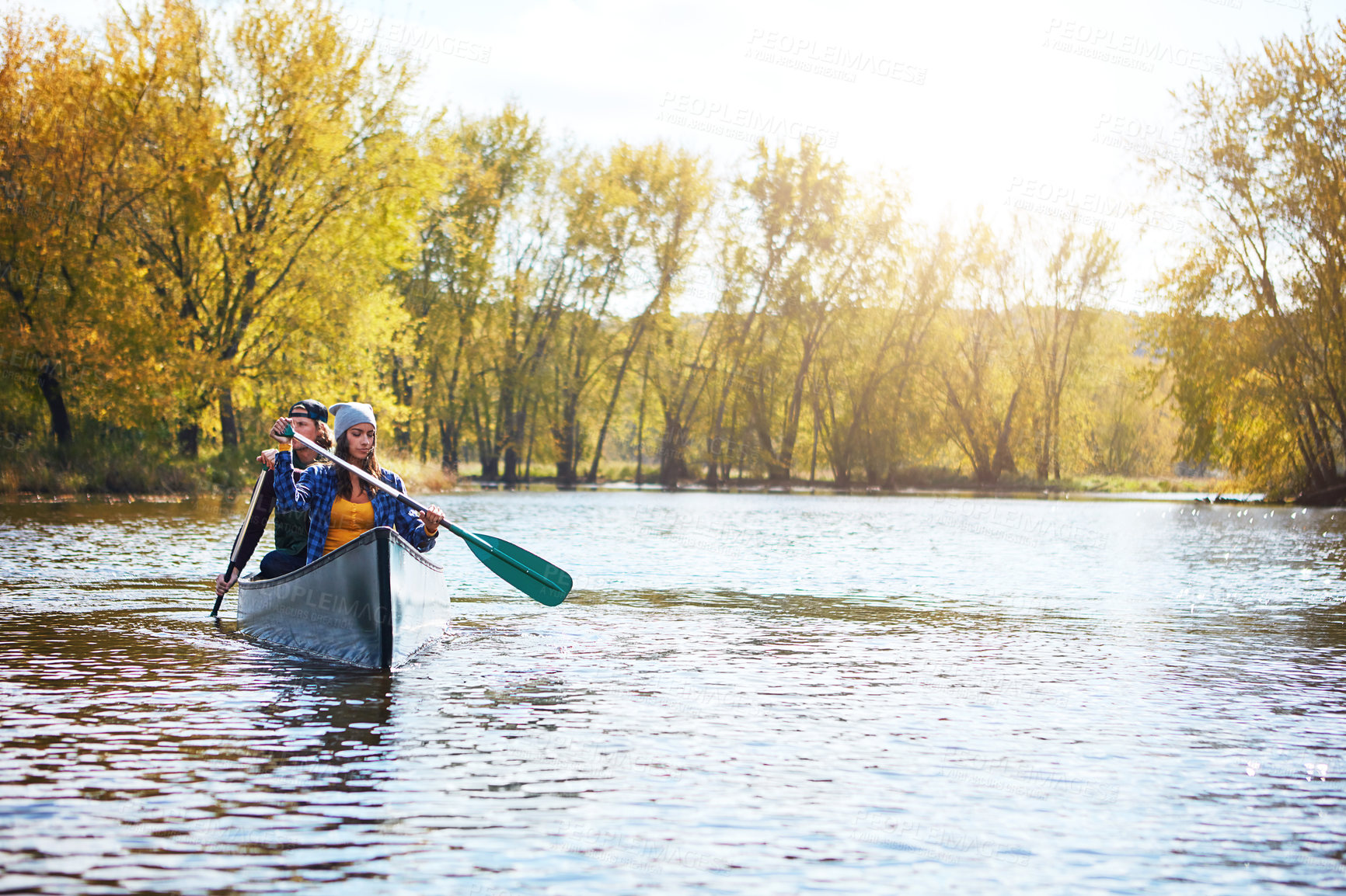 Buy stock photo Shot of a young couple going for a canoe ride on the lake