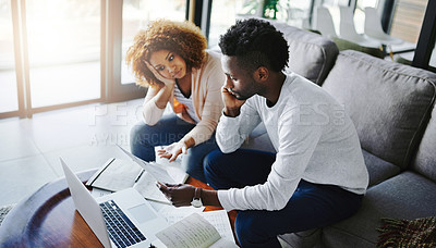 Buy stock photo Shot of a young couple looking anxious while doing their budget at home