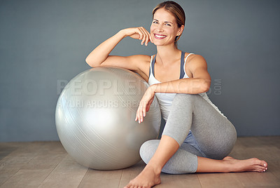 Buy stock photo Shot of a sporty young woman sitting next to her fitness ball