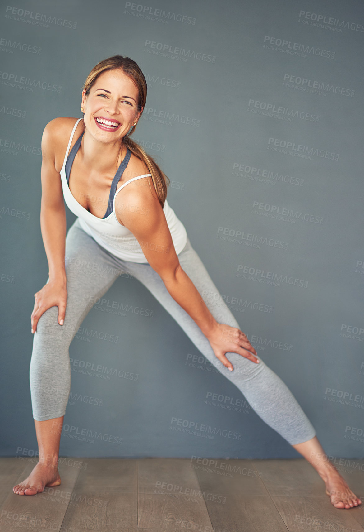 Buy stock photo Fitness, smile and stretching with portrait of woman in studio for health, wellness or yoga. Exercise, pilates and warm up with happy person on gray background for balance or holistic routine