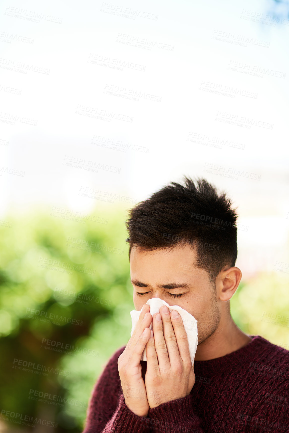 Buy stock photo Cropped shot of a young man blowing his nose outside