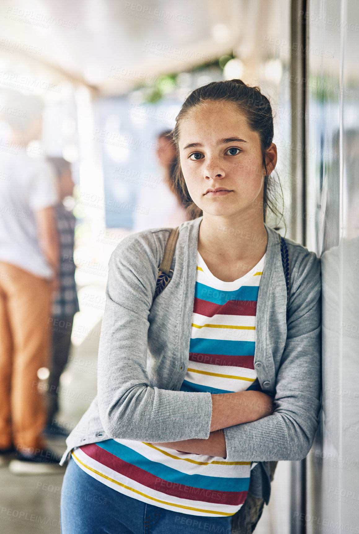 Buy stock photo Young girl, portrait and lonely at school with classroom in learning academy or institute. Female person, teenager or learner leaning on wall alone with arms crossed at outdoor campus or college