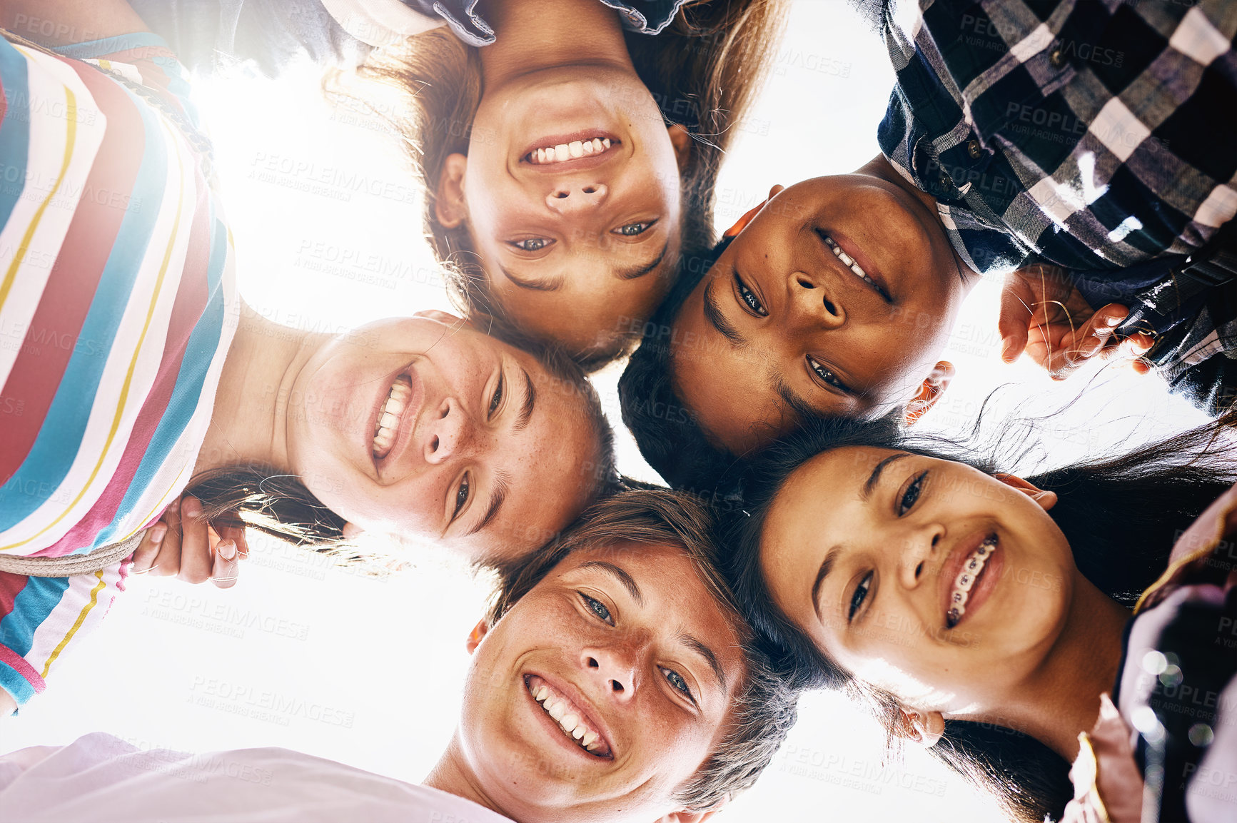 Buy stock photo Huddle, portrait and happy children in school for education, support or development. Low angle, diversity and group of friends with smile in playground for solidarity, teamwork or playing together