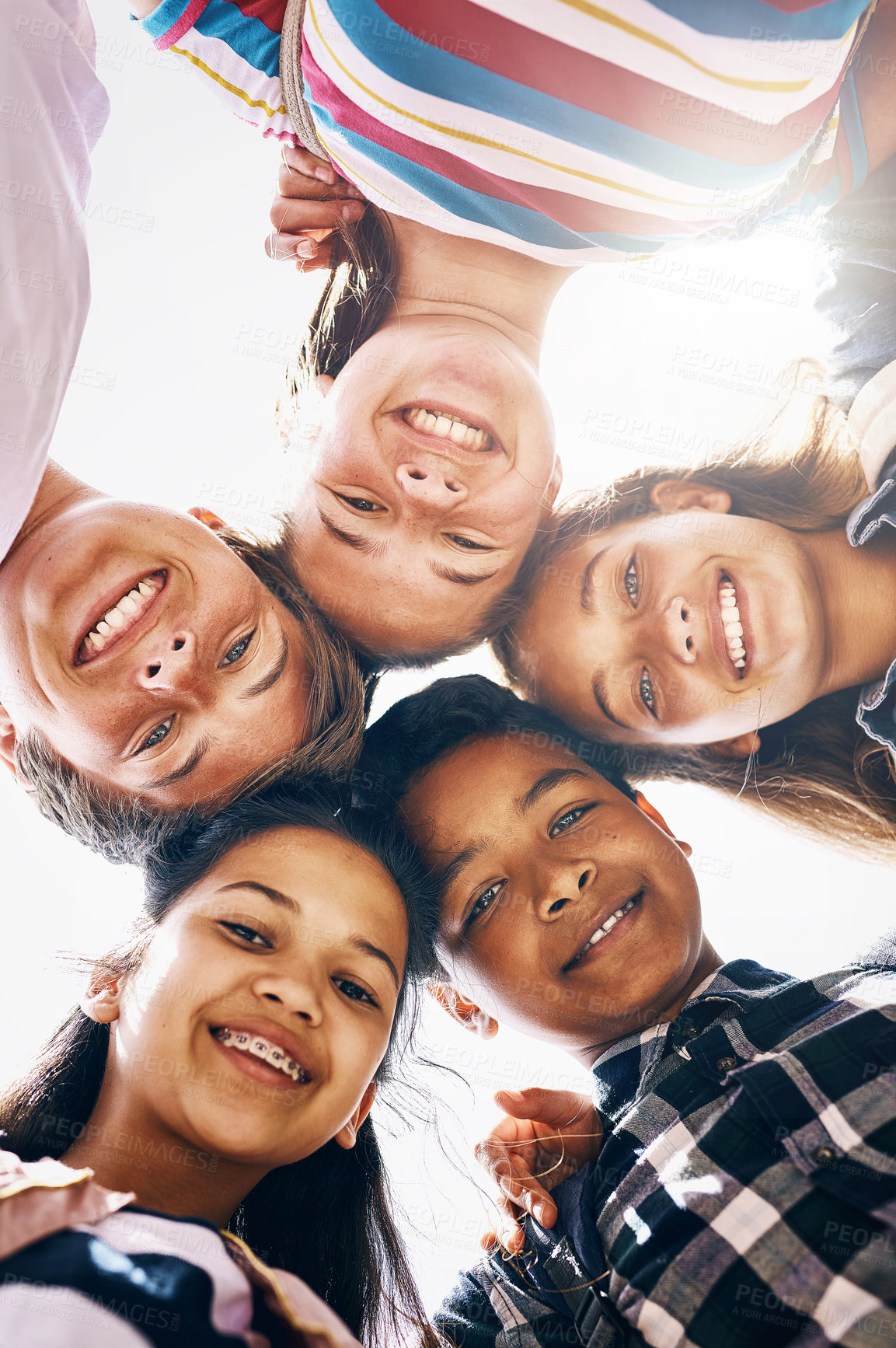 Buy stock photo Low angle portrait of a group of diverse schoolchildren standing in a huddle