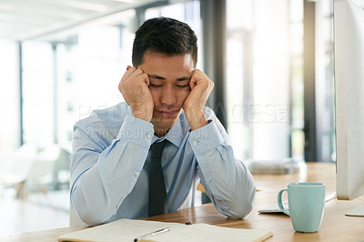 Buy stock photo Cropped shot of a young businessman looking stressed while sitting at his desk