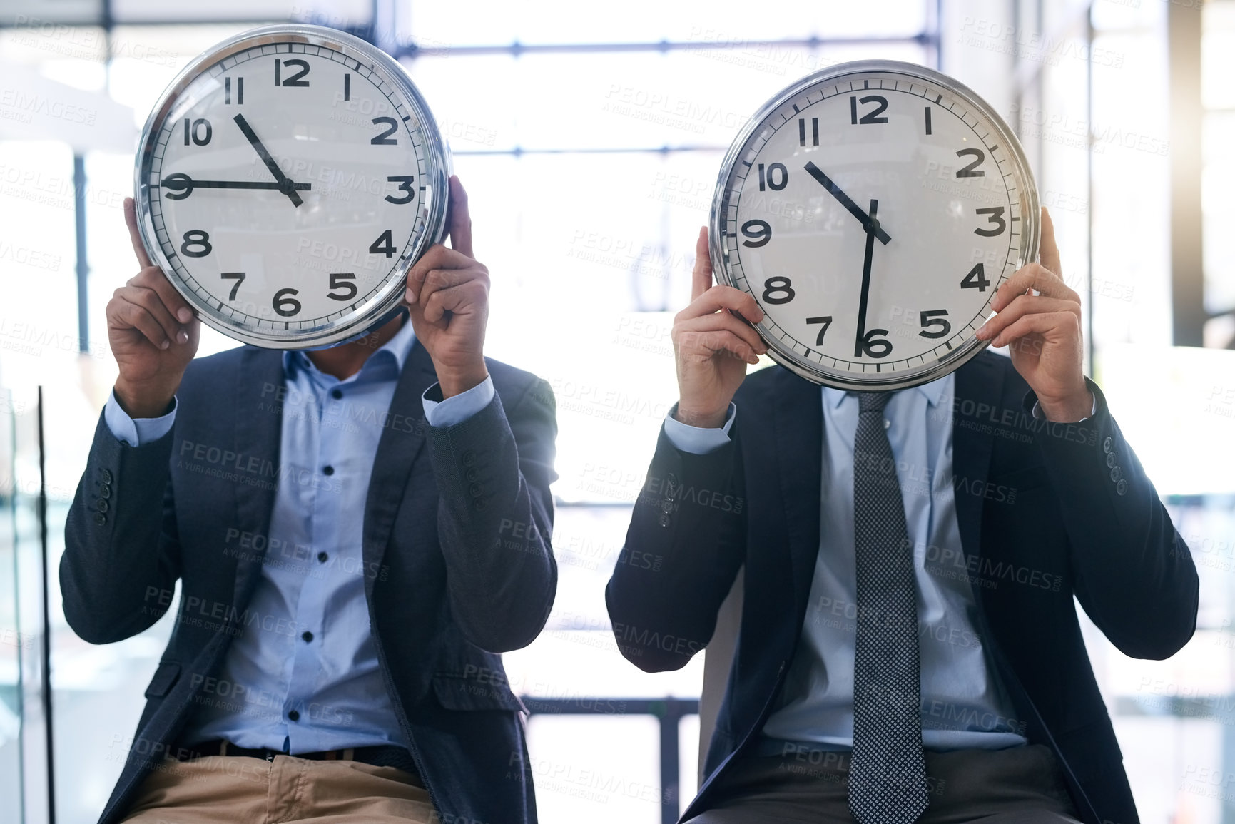 Buy stock photo Cropped shot of two businessmen holding clocks over their faces in the office