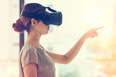 Buy stock photo Shot of a young businesswoman wearing a VR headset while connecting to a user interface in an office