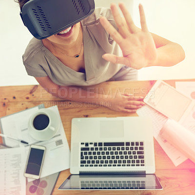 Buy stock photo High angle shot of a young businesswoman wearing a VR headset while working in an office