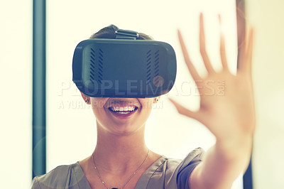Buy stock photo Shot of a young businesswoman wearing a VR headset while connecting to a user interface in an office
