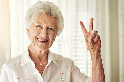 Buy stock photo Portrait of a happy elderly woman showing a peace gesture at home