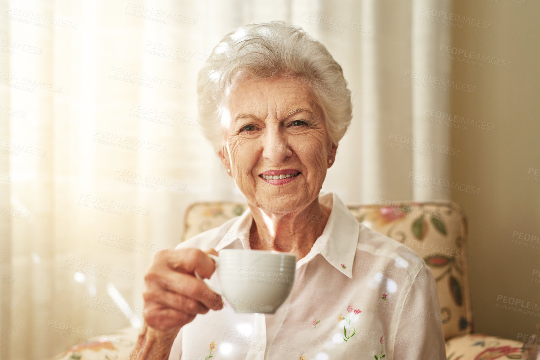 Buy stock photo Portrait of a happy elderly woman enjoying a cup of tea at home