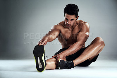 Buy stock photo Full length shot of a sporty young man warming up against a grey background