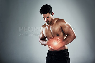 Buy stock photo Cropped shot of a sporty young man holding his stomach in pain against a grey background