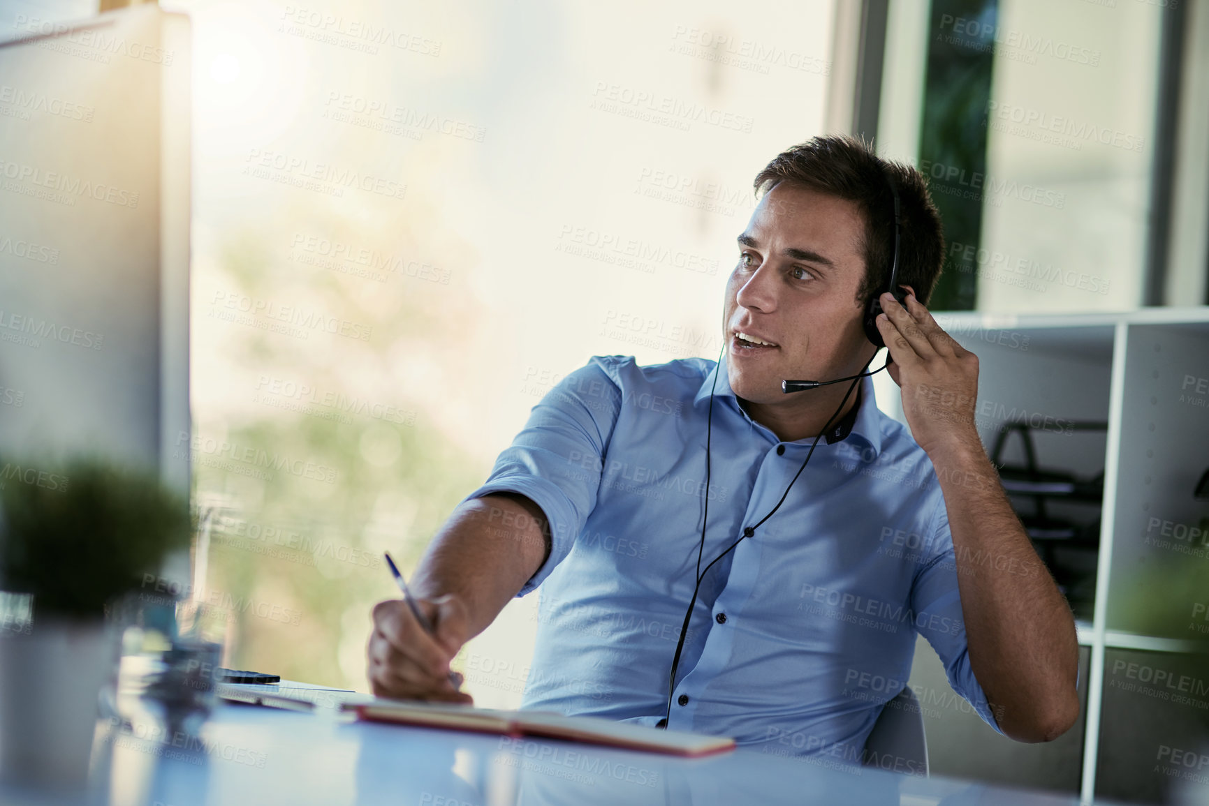 Buy stock photo Callcenter agent, smile and notes, man consulting with advice, sales information and help desk. Phone call, conversation and customer support consultant writing in notebook while speaking in office.