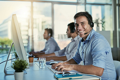 Buy stock photo Customer service, coworking space and portrait of happy man consulting with advice and smile at help desk. Phone call, conversation and happiness, callcenter consultant typing at computer in office.
