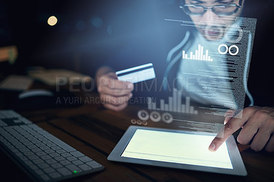 Buy stock photo Shot of a young hacker using a digital tablet to commit credit card fraud in the dark