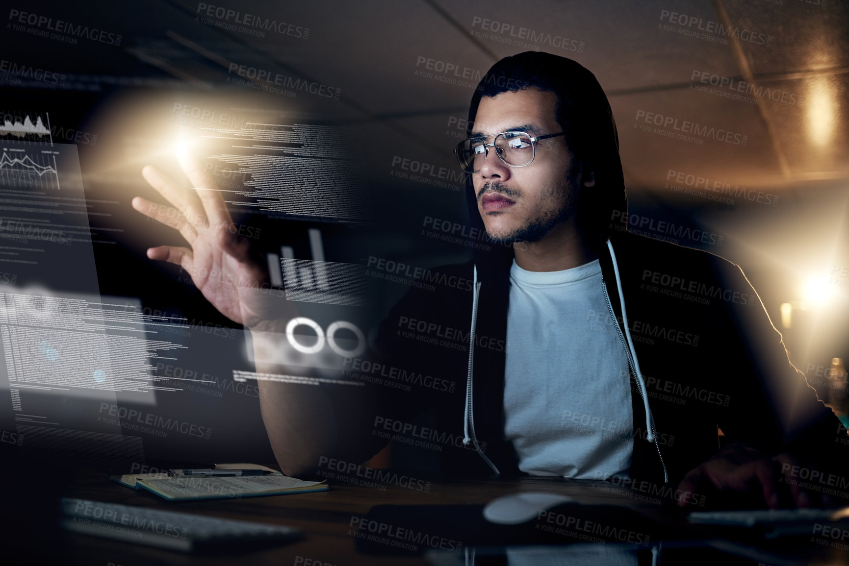 Buy stock photo Shot of a young hacker cracking a computer code in the dark