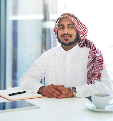Buy stock photo Portrait of a confident young muslim businessman working at his desk in a modern office