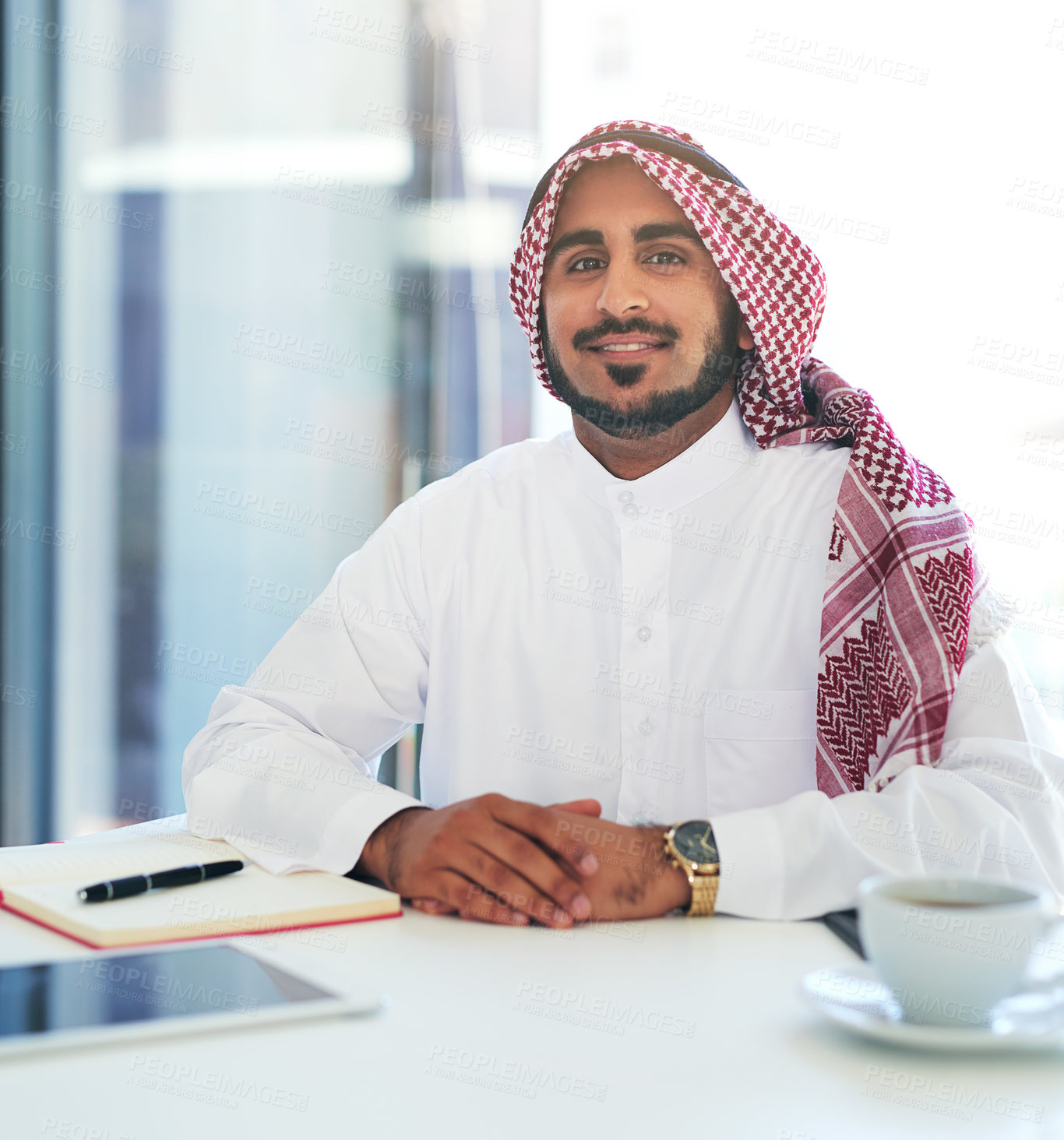 Buy stock photo Portrait of a confident young muslim businessman working at his desk in a modern office