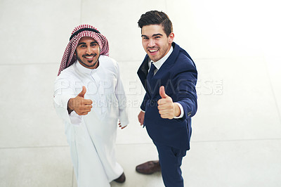 Buy stock photo Portrait of a young muslim businessman and his colleague showing thumbs up in a modern office