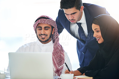 Buy stock photo Shot of a team of muslim coworkers using a laptop together in a modern office