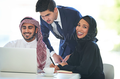 Buy stock photo Portrait of a team of muslim coworkers using a laptop together in a modern office