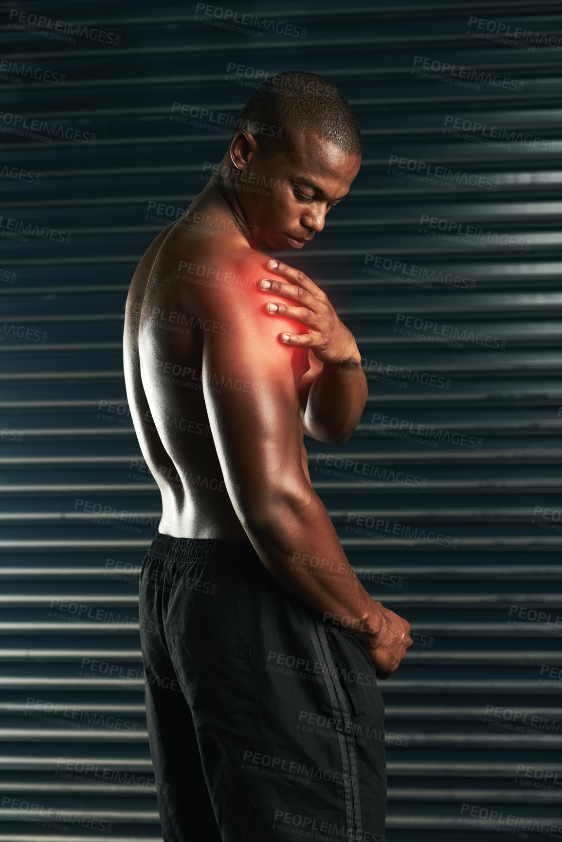 Buy stock photo Studio shot of an athletic young man examining a shoulder injury during his workout