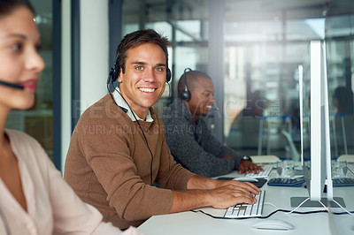 Buy stock photo Portrait of a call centre agent working alongside his colleagues in an office