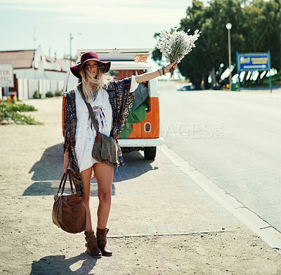 Buy stock photo Shot of a young hipster woman hitchhiking at the side of the road with her broken down van in the background