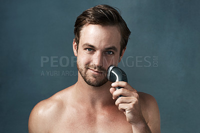 Buy stock photo Shaver, electric or portrait of man with beard or hair removal for skincare or cosmetics in studio. Face, smile or confident male person on blue background for beauty, facial treatment or wellness