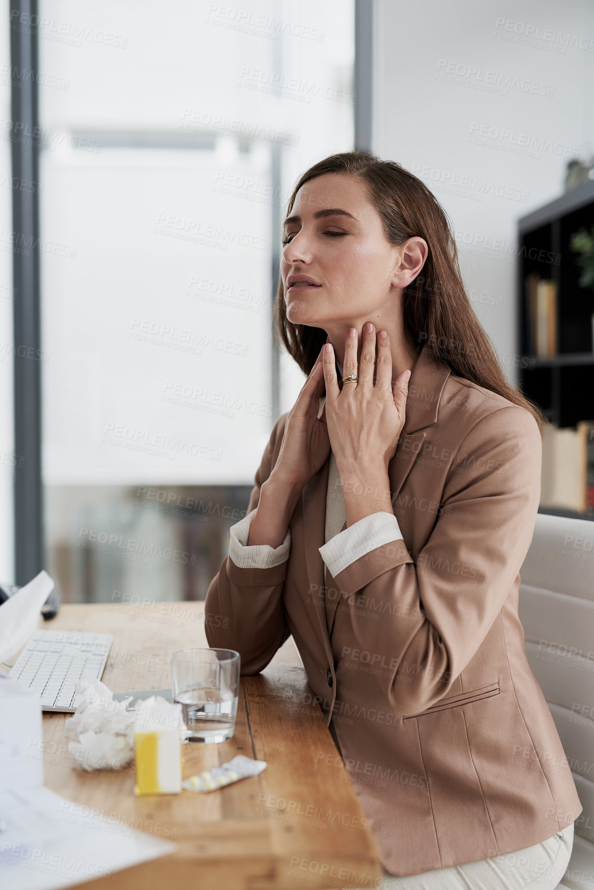 Buy stock photo Shot of a young businesswoman experiencing throat pain while working in an office