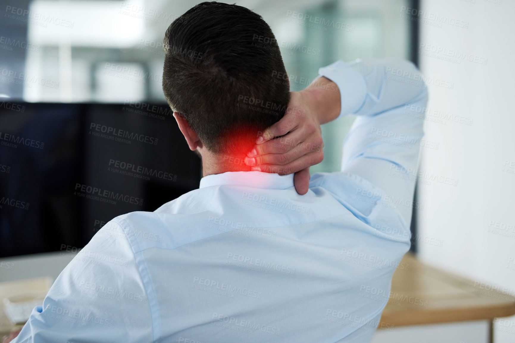 Buy stock photo Rearview shot of a young businessman experiencing neck pain highlighted in glowing red at work