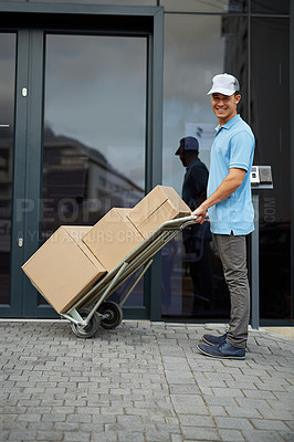 Buy stock photo Box, portrait or trolley with a happy delivery guy by office for entrance for online shopping or product. Apartment, hand truck or courier man with stock by a home for ecommerce service or package
