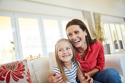 Buy stock photo Portrait of a mother and  her young daughter sitting together in the living room at home