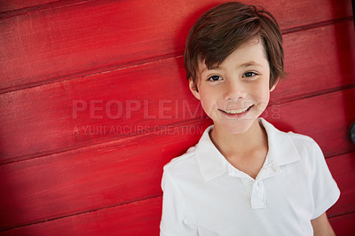 Buy stock photo Portrait of a smiling little boy standing against a red wall