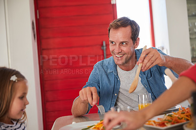 Buy stock photo Shot of a happy family enjoying a home-cooked meal together at the table
