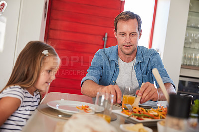 Buy stock photo Shot of a happy family enjoying a home-cooked meal together at the table