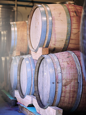 Buy stock photo Shot of barrels of wine stacked on each other in a wine distillery