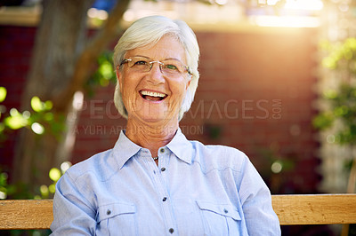 Buy stock photo Portrait of a happy senior woman relaxing on a bench in the garden