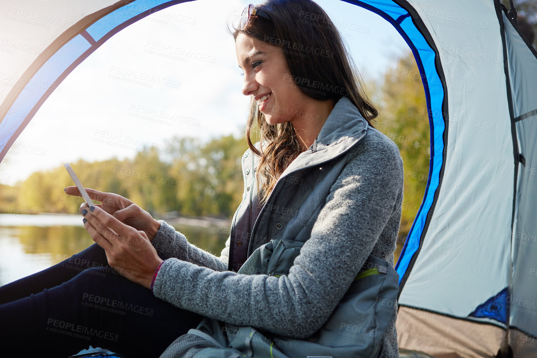 Buy stock photo Cropped shot of an attractive young woman sitting at her campsite